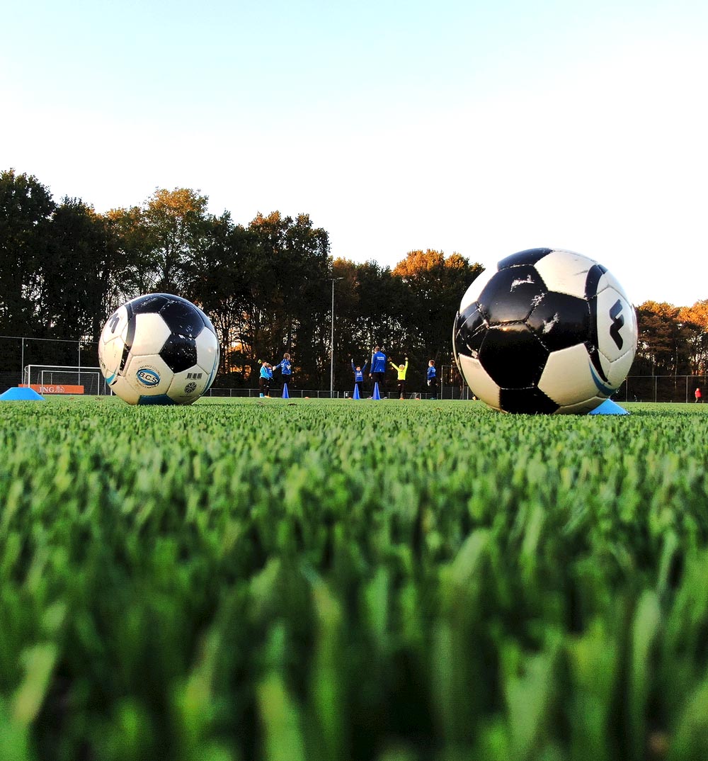 Voetballen op veld tijdens keeperstraining